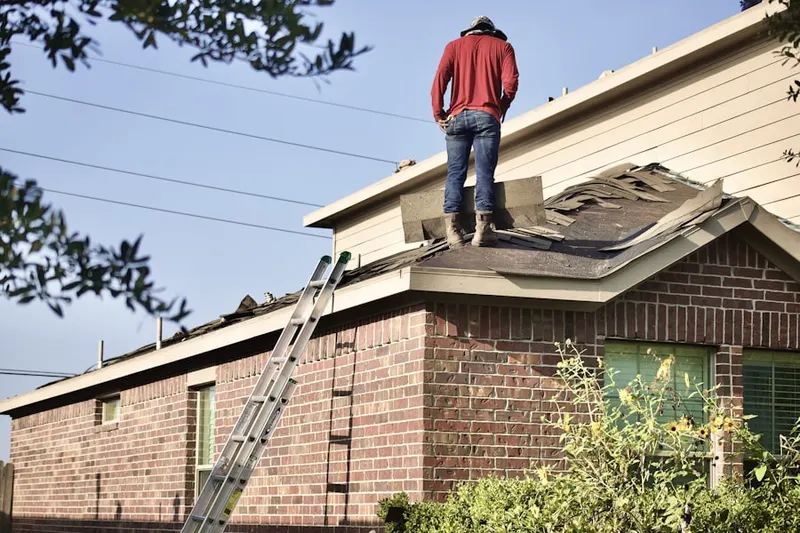 Professional roofer working on a residential roof in Ives Estates